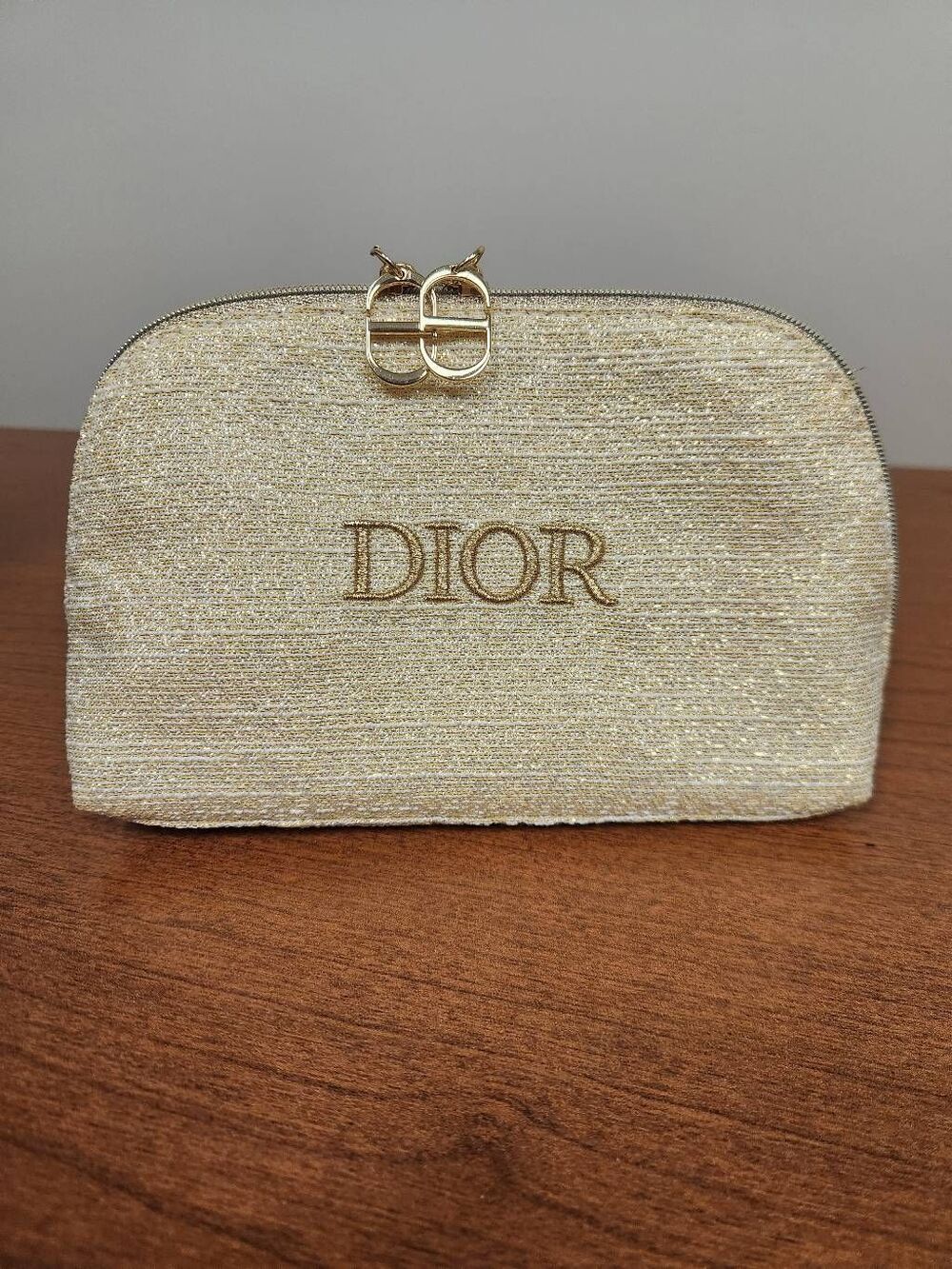 Christian Dior Holiday 2024 cosmetic shimmering gold pouch featuring an embroide